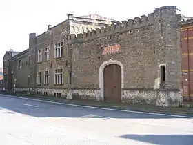 La façade avant limitée à gauche par la tour semi-hexagonale du château et à droite par celle limitant la partie de la façade comprenant la porte cochère de l'ancienne usine Impéria à Nessonvaux