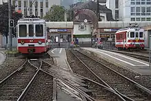 Gare ferroviaire terminus avec plusieurs trains blancs et rouges à l'arrêt.