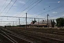 Gare ferroviaire et dépendances (hangar aux marchandises et sanitaires) : façades et toitures, deux anciennes salles d'attente, plafonds de bois à caisson et grilles extérieures primitives