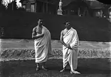 Photographie noir et blanc de deux hommes debout en toge.