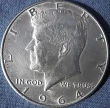 Revers d'un pièce de monnaie avec la tête du président Kennedy, regardant vers la gauche.