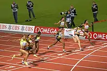 Fin d'une course féminine de 100 mètres.