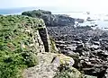 Pierre de davier percée d'un trou et muret de soutènement en sommet de falaise à l'est des Rospects.