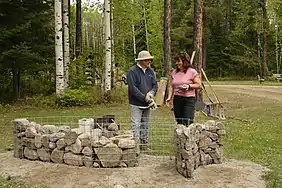 Jocelyn Maltais, artiste du collectif Interaction Qui discutant avec une participante au projet d'implantation du Tacon Site des Forêts.