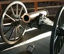 Photographie d'un canon avec des roues en bois.
