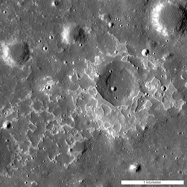 Image majoritairement grise, on voit des cratères sombres et des zones blanches les entourant.