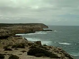 Vue distante de falaises avec la mer sur la droite