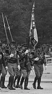 le drapeau du 3e régiment étranger porté par un légionnaire, encadré par la garde d'honneur du drapeau
