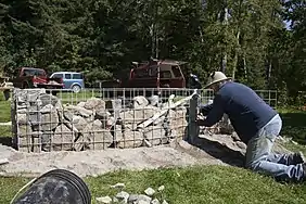 L'artiste Jocelyn Maltais plaçant quelques roches dans le Tacon Site des Caps.