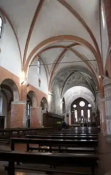 La nef de l'abbatiale, avec ses piliers de briques ; la voûte du transept décorée de fresques ; au fond, le fond de l'abside plat et ses trois verrières, typiquement cisterciennes.