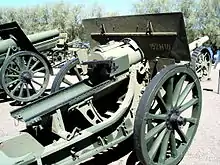 Un canon ancien, verdâtre, exposé au milieu d'autres canons.