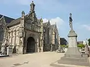 Bodilis : le monument aux morts et le porche sud de l'église paroissiale Notre-Dame.