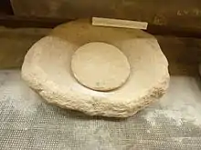 Meule dormante (partie fixe) et molette trouvées sur le site de La Torche (Musée de la préhistoire finistérienne de Penmarc'h).