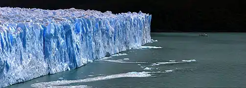 Une portion du front glaciaire nord est explorée par un bateau touristique. Le bateau offre une idée de la taille du glacier.