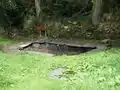 Le lavoir du Lapig, entouré de pierres de schistes ardoisiers.