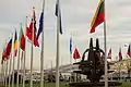 Les drapeaux des pays de l'OTAN, ainsi que la sculpture La Rose des Vents (2016).