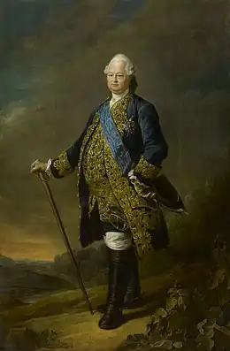 Portrait en pied, en costume bleu aux broderies dorées, canne à la main dans un paysage
