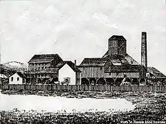Gravure en noir et blanc montrant de nombreux bâtiments en bois ou maçonnés surmontés d'une cheminée et d'un clocher en bois abritant le chevalement.