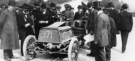 Photo d'Henri Béconnais au volant de sa Darracq et entouré par des officiels de la course.