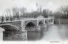 Photographie en noir et blanc d'un pont sur une rivière.