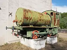 Photographie d'une locomotive à vapeur sur un socle dans la cour d'un musée.