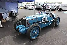 Photo d'une voiture de course bleue dans un stand.