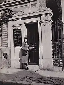 Portail d'entrée avec panneau d'horaires, en 1941.