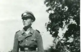 Photo en noir et blanc d'un très jeune homme en uniforme militaire, avec une casquette.