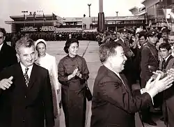  le prince, sur le tarmac, serre des mains dans la foule sous le regard de son épouse Monique et des époux Ceaușescu