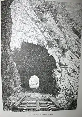 Photo en noir et blanc de l'extérieur d'un tunnel dont on voit le bout.