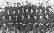 Un grand groupe d'hommes en uniformes militaires posent pour une photo.