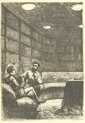 Deux hommes discutant assis sur un divan dans une bibliothèque.