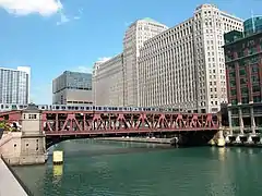 Vue sur le Merchandise Mart et le pont de Wells Street sur lequel traverse une rame du métro de Chicago.