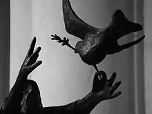 photo : détail d'une statue montrant les mains de Noé lâchant la colombe
