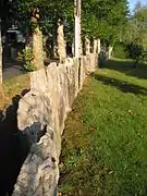 Vue d’une clôture de pré en pierres dressées.