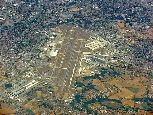 Vue aérienne de l'aéroport de Toulouse (été 2006) : usines d'AéroConstellation au premier plan, Blagnac à gauche. Toulouse couvre les zones urbanisées restantes (stade, périphérique, coulée verte du Touch, usines d'Airbus dans le quartier de Saint-Martin-du-Touch). Colomiers se trouve à l'extrême droite.