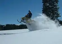 Photo d'un Ski-Doo sautant une dune de neige.