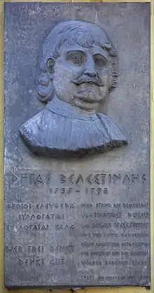 photographie d'une plaque de bronze avec le portrait d'un homme moustachu et du texte en grec