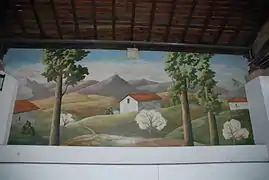 Photographie d'une fresque montrant un paysage de montagnes avec des maisons couvertes de tuiles.
