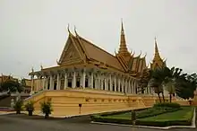 Photo contemporaine d'un palais de style khmer, au toit doré et richement décoré.