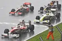 Photo des voitures de Barrichello, Trulli, Hamilton et Webber arrêtées sur une piste détrempée