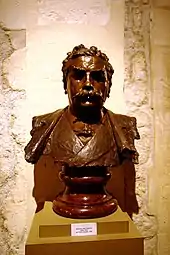 Photo d'un buste d’un homme moustachu à l’air sévère