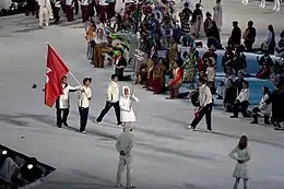 Han Yueshang portant le drapeau de Hong Kong devant deux autres sportifs.