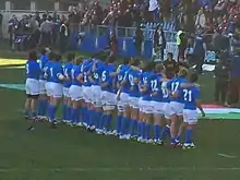 Photographie d'une équipe de rugby en ligne, portant des maillots bleus