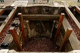 Le puits recreusé et restauré laisse voir ses guides en bois et sa tuyauterie.