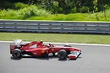 Massa lors de son Grand Prix national, au volant de sa Ferrari rouge, sous un grand soleil.