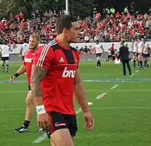 Joueur de rugby marchant, vu de profil.