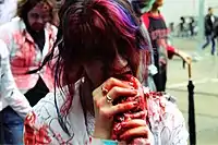 Mise en scène d'une attaque de zombie par une personne déguisée durant une marche des zombies de 2011 à Toronto (Canada).
