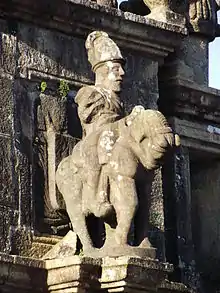 Statue en pierres représentant un cavalier casqué.