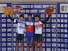 Photo de trois coureurs sur un podium.